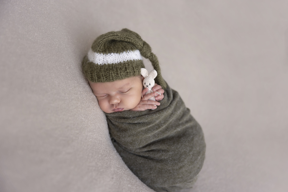 newborn fotoshoot urk, baby geposeerd op een kleedje met konijn